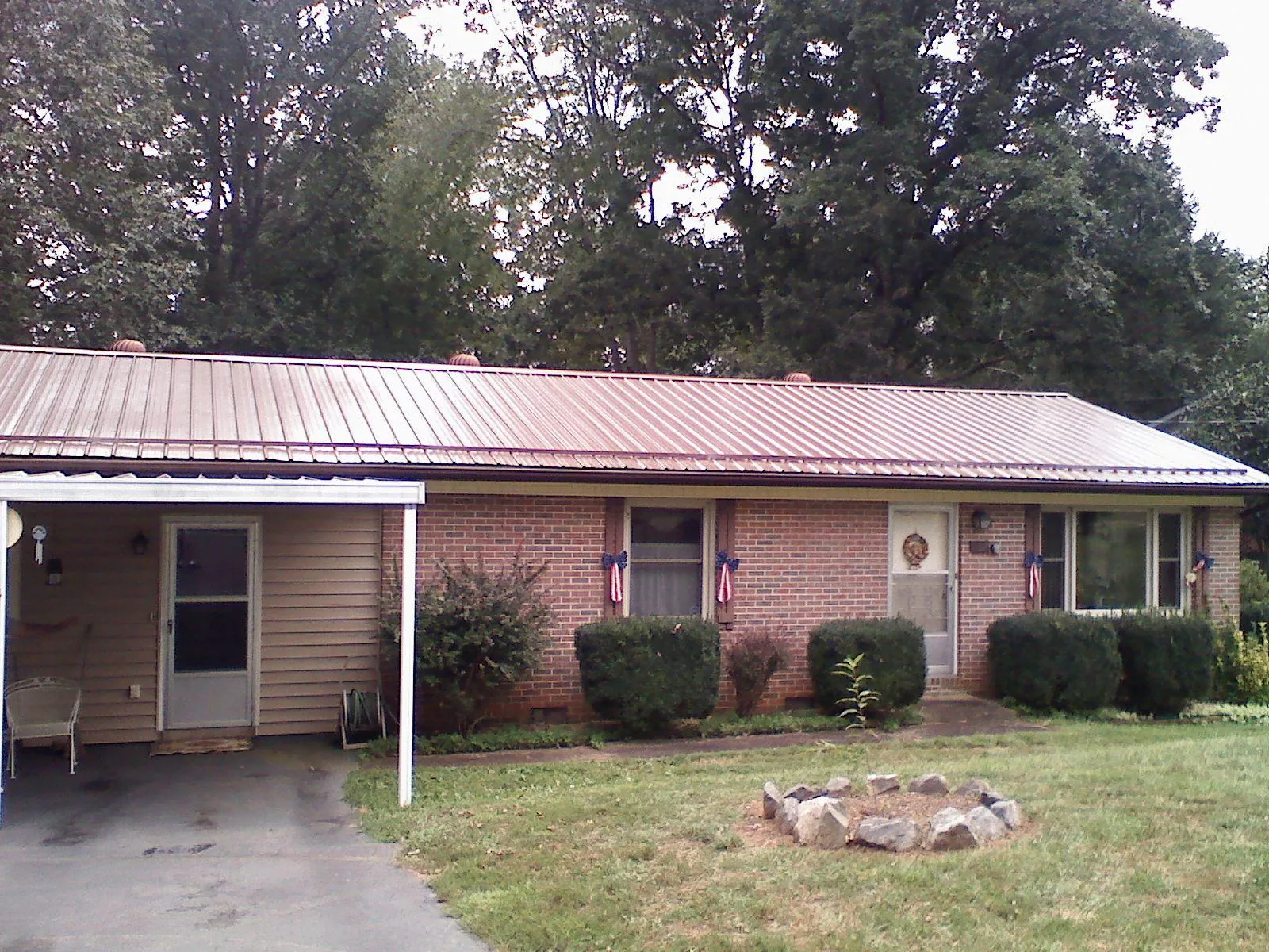 Bronze metal roof and carport on a brick ranch home — Roof Repair work by our crew in New River